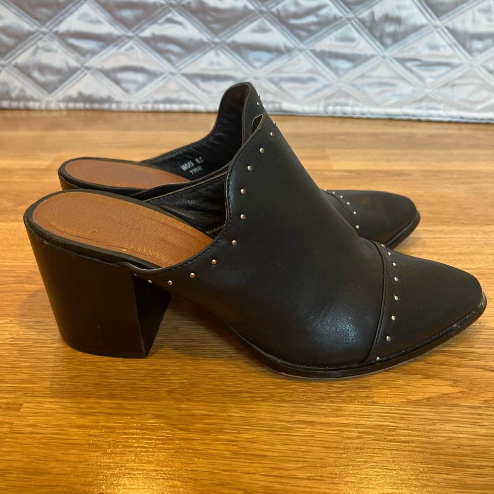 Report black mules with silver hardware accents